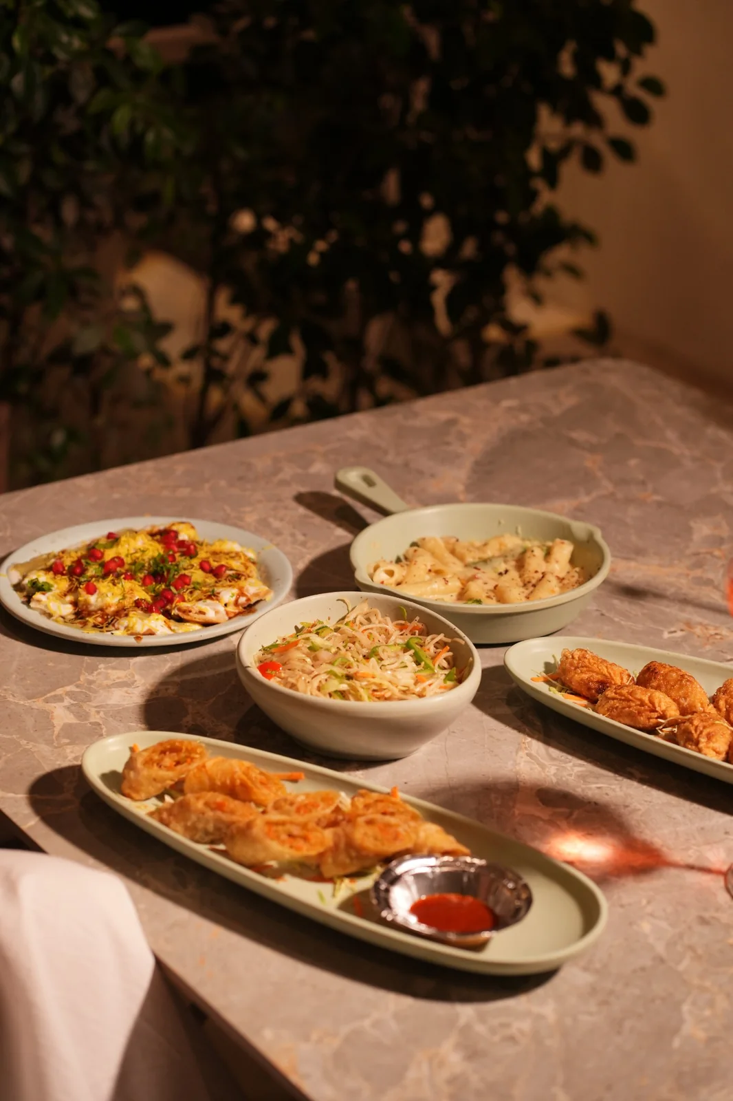 A selection of pasta, noodles, chaat and fried snacks on a cafe table. Nasha Chai Sutra, SFS Mansarovar Jaipur.