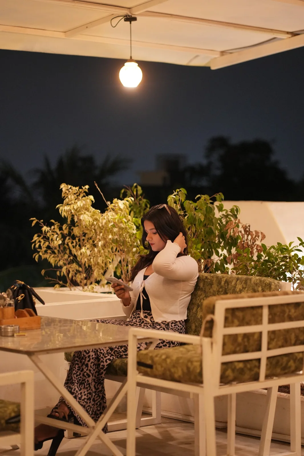 A guest seated among the cafe tables and chairs. Nasha Chai Sutra, SFS Mansarovar Jaipur.